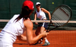 Two young sporty female tennis players having a game in the sun.